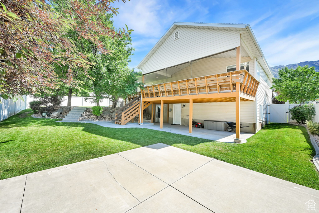 Rear view of house featuring a patio area, stairs, a deck with mountain view, and a gate
