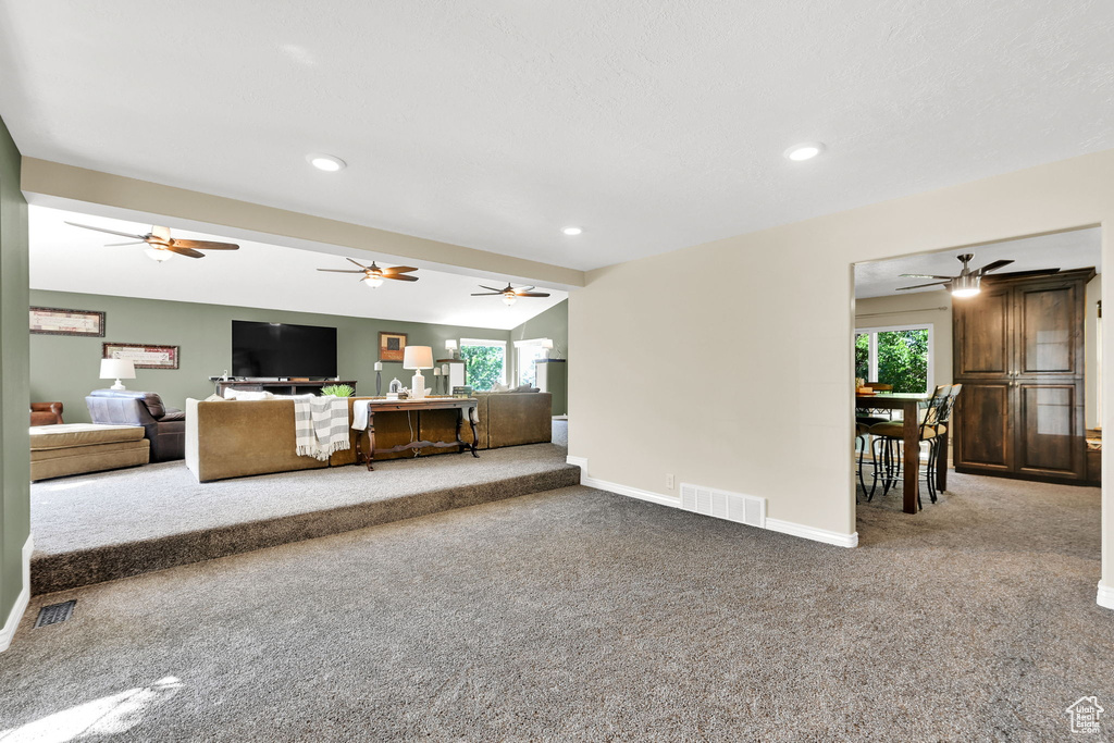 Living area with carpet, baseboards, ceiling fan, and recessed lighting