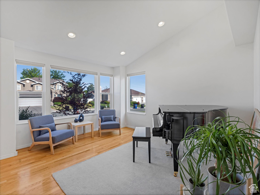 Living area with wood finished floors, vaulted ceiling, recessed lighting, and baseboards
