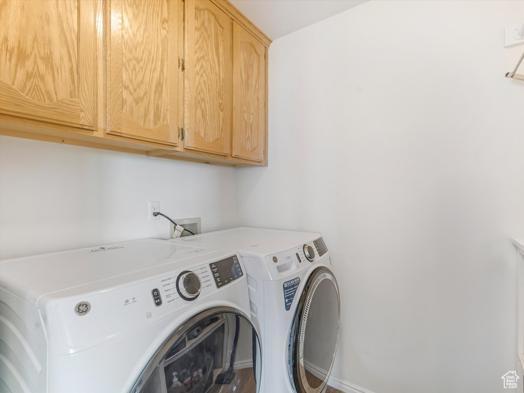 Washroom featuring cabinet space and separate washer and dryer