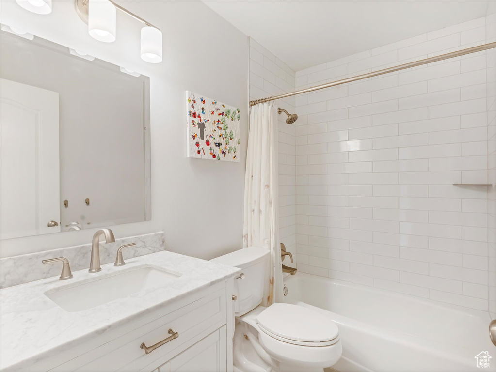 Full bath featuring vanity, toilet, and shower / bath combination with curtain