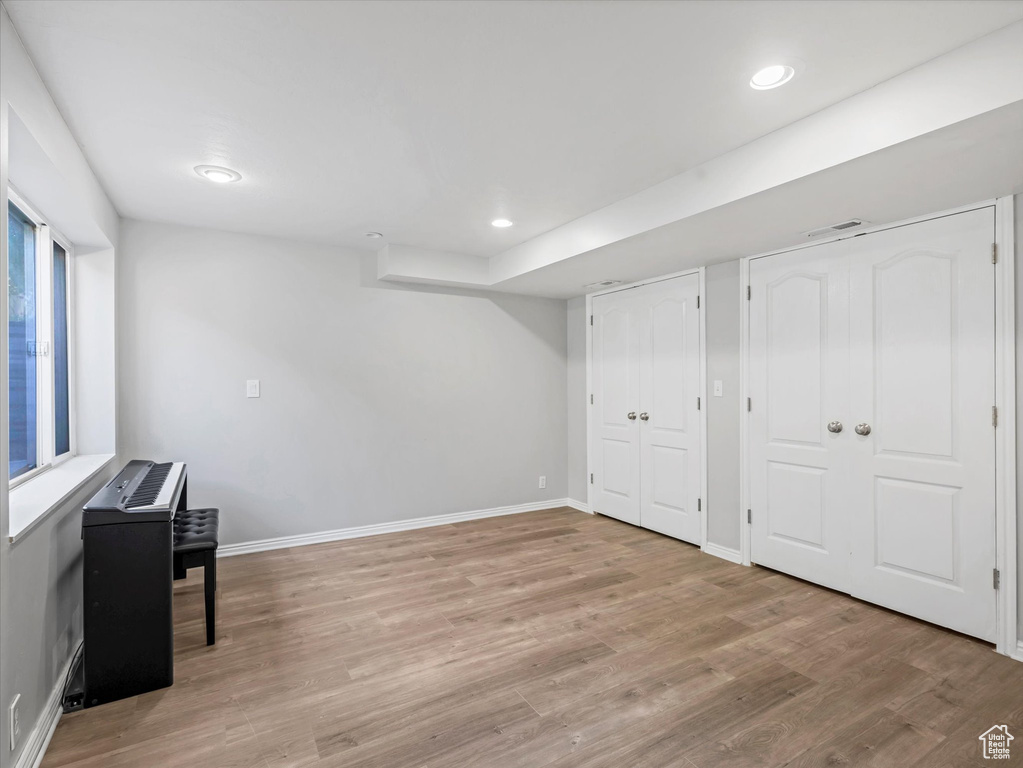 Basement with light wood-style flooring, baseboards, and recessed lighting