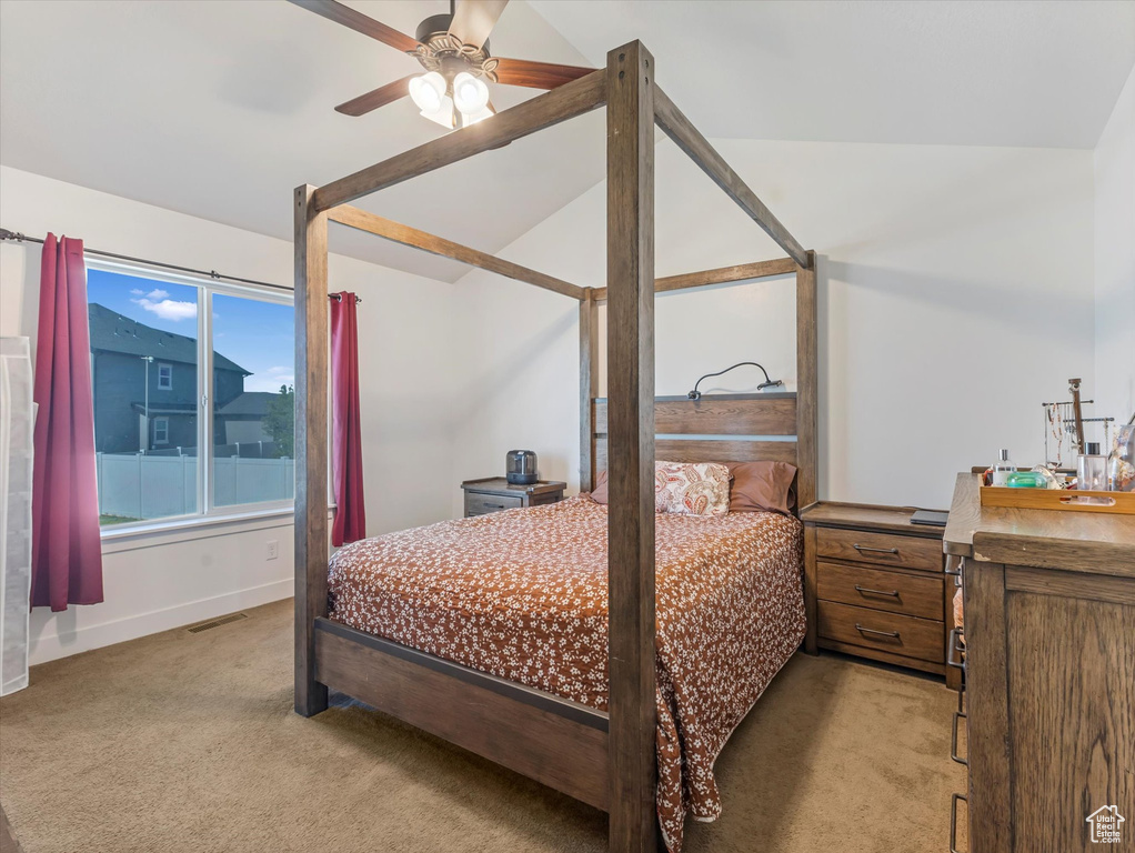 Bedroom with light colored carpet, vaulted ceiling, baseboards, and a ceiling fan