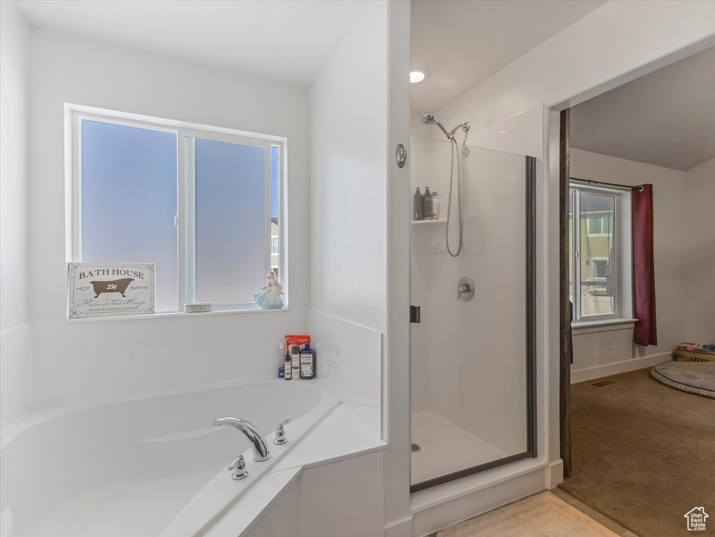 Bathroom featuring a stall shower and a bath