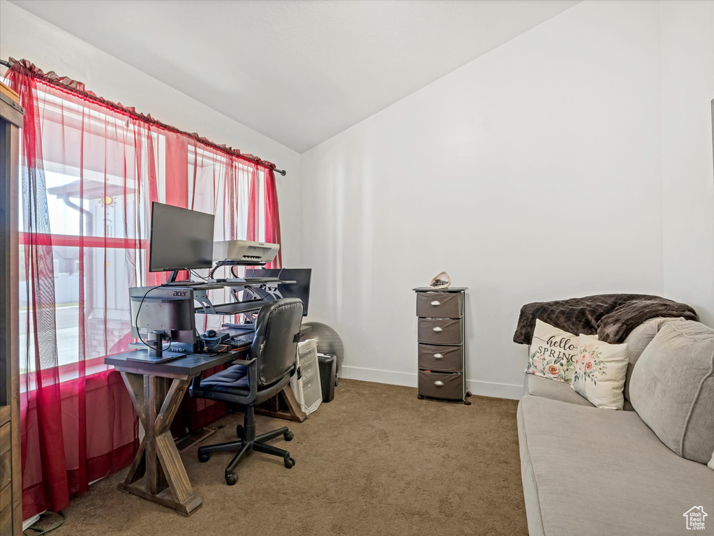 Carpeted office with vaulted ceiling and baseboards