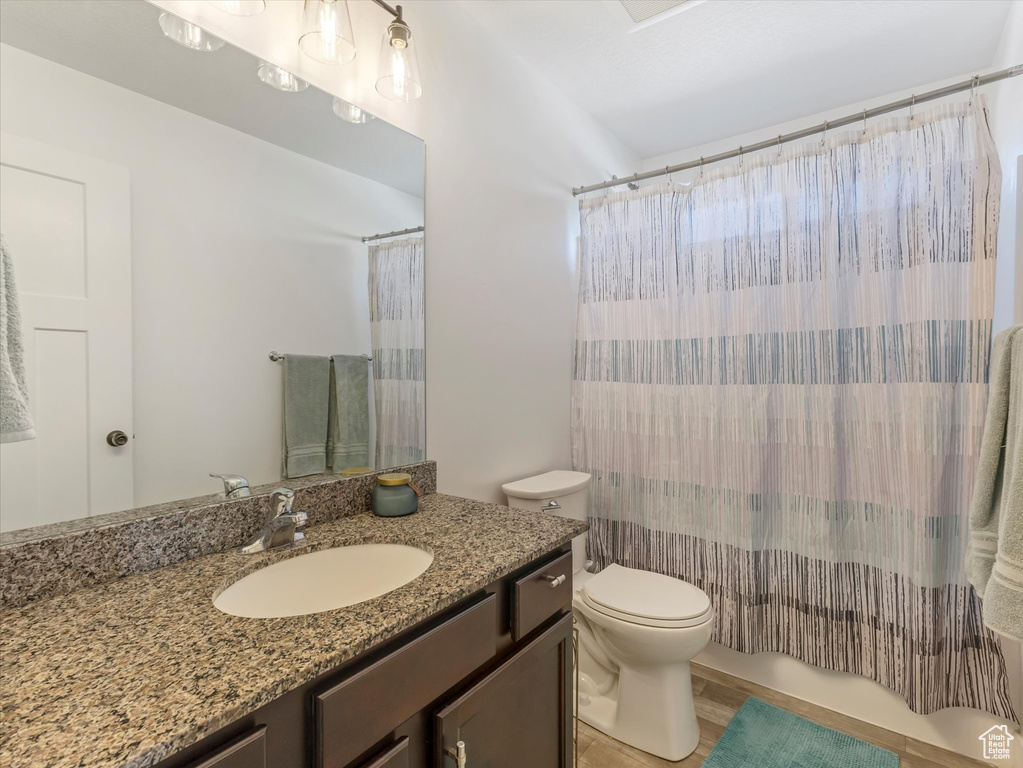Bathroom featuring toilet, vanity, and wood finished floors