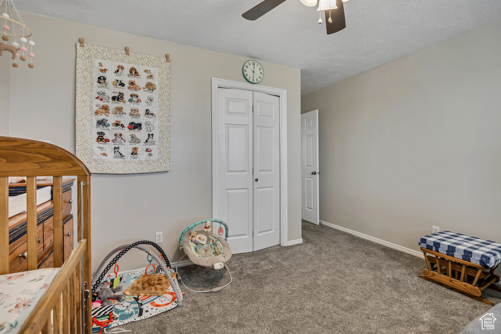 Bedroom with carpet, a closet, baseboards, and a ceiling fan