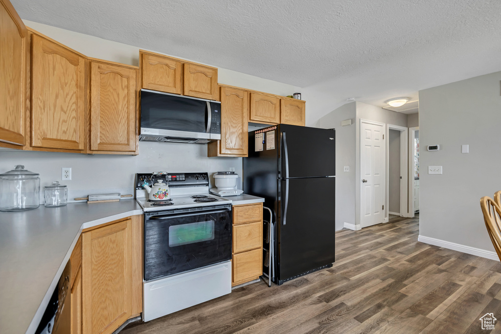 Kitchen featuring stainless steel microwave, freestanding refrigerator, electric range, dark wood-style flooring, and a textured ceiling