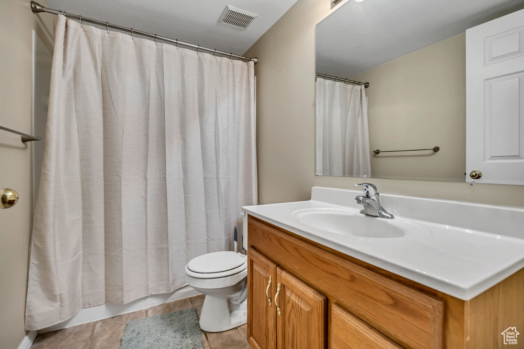 Bathroom featuring vanity, toilet, and tile patterned floors