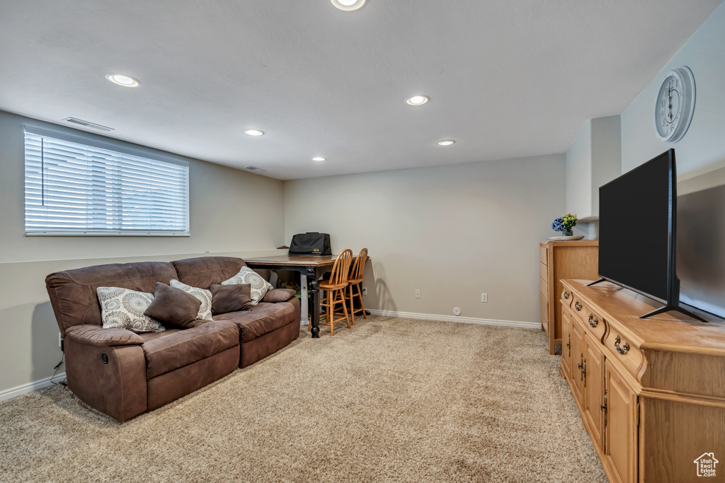 Living area with light colored carpet, recessed lighting, and baseboards