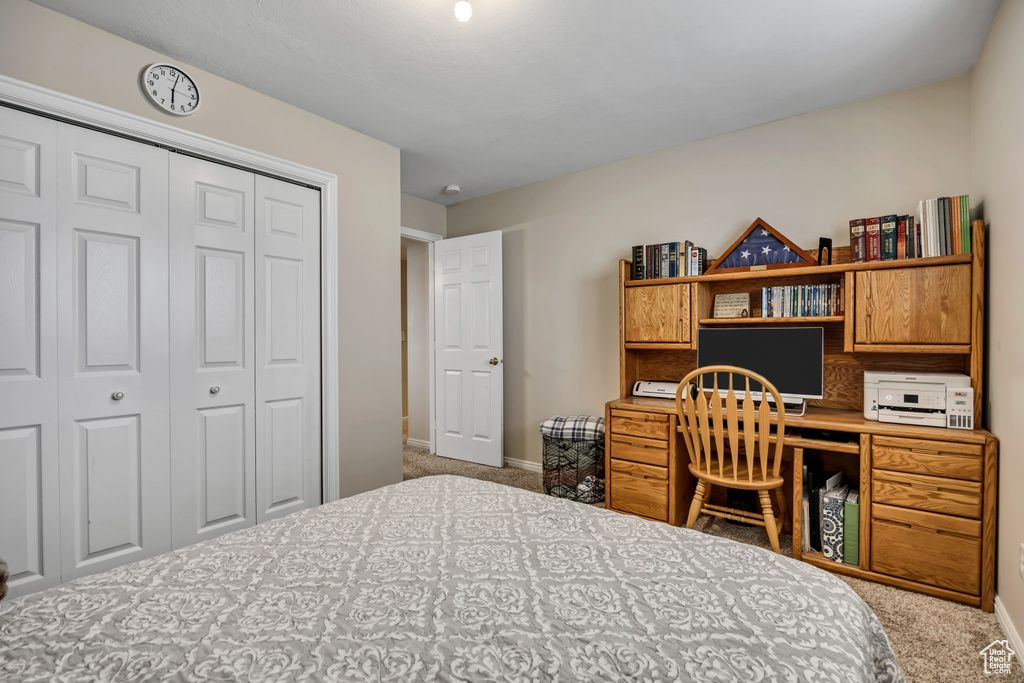 Carpeted bedroom with a closet and baseboards