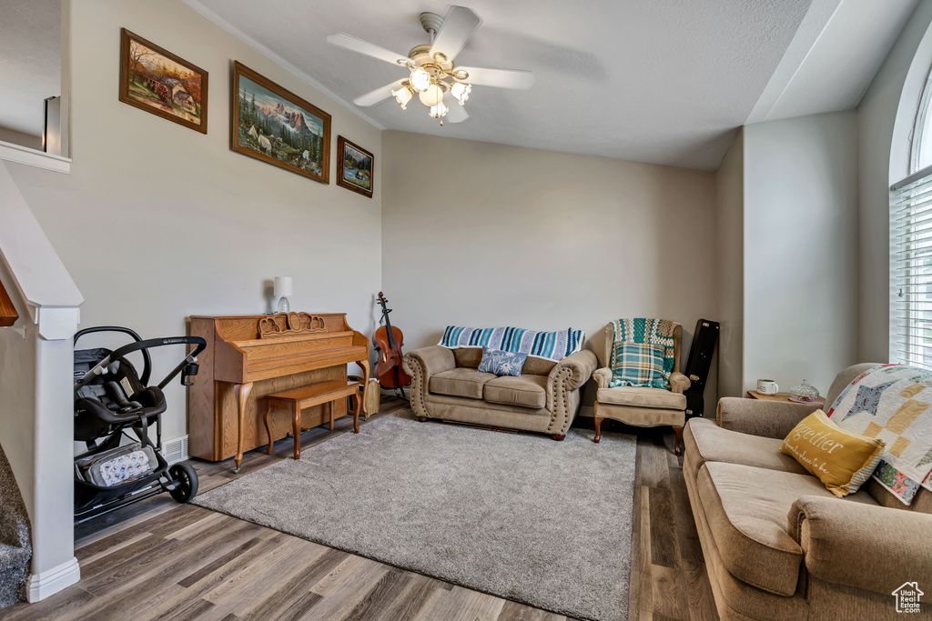Living room with wood finished floors and a ceiling fan