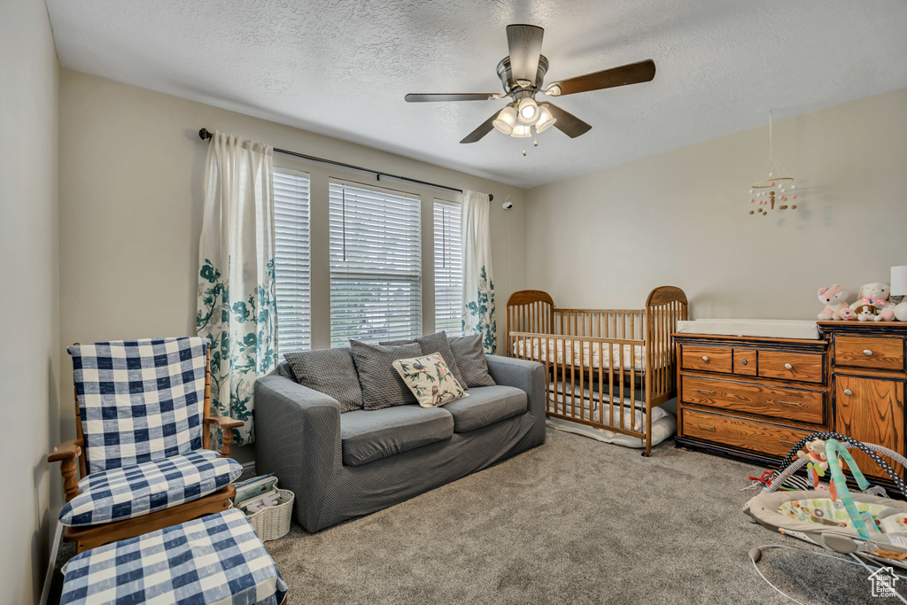 Carpeted bedroom featuring a textured ceiling and ceiling fan