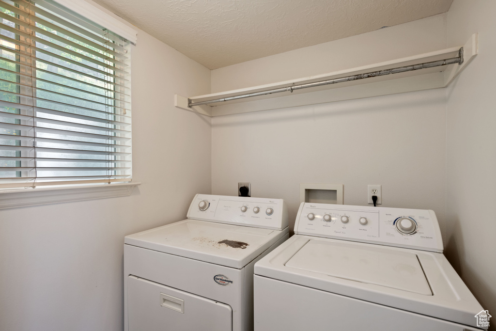 Laundry area featuring washer and clothes dryer and a textured ceiling