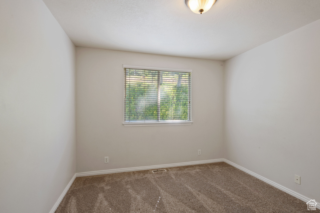 Empty room with carpet flooring and baseboards