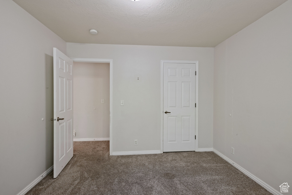Unfurnished bedroom featuring carpet floors and baseboards
