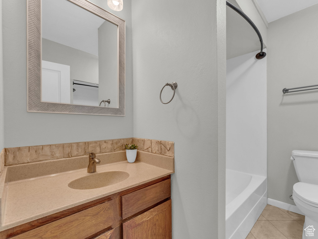 Bathroom with toilet, tile patterned floors, and vanity