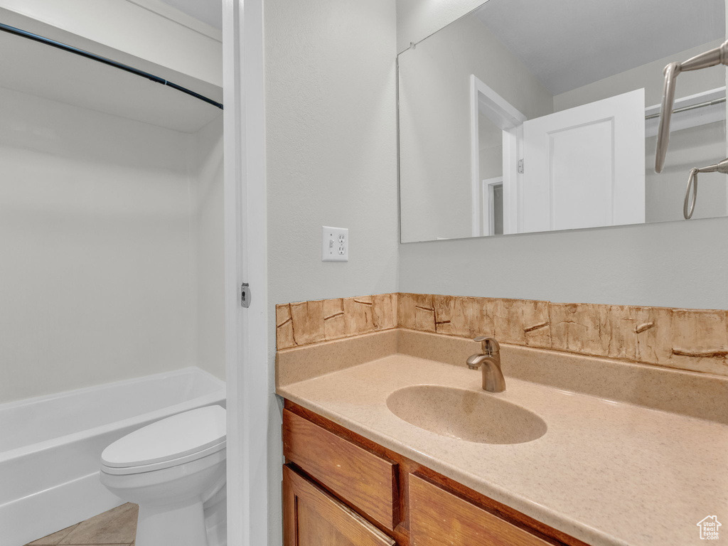 Bathroom featuring toilet, vanity, and tile patterned floors