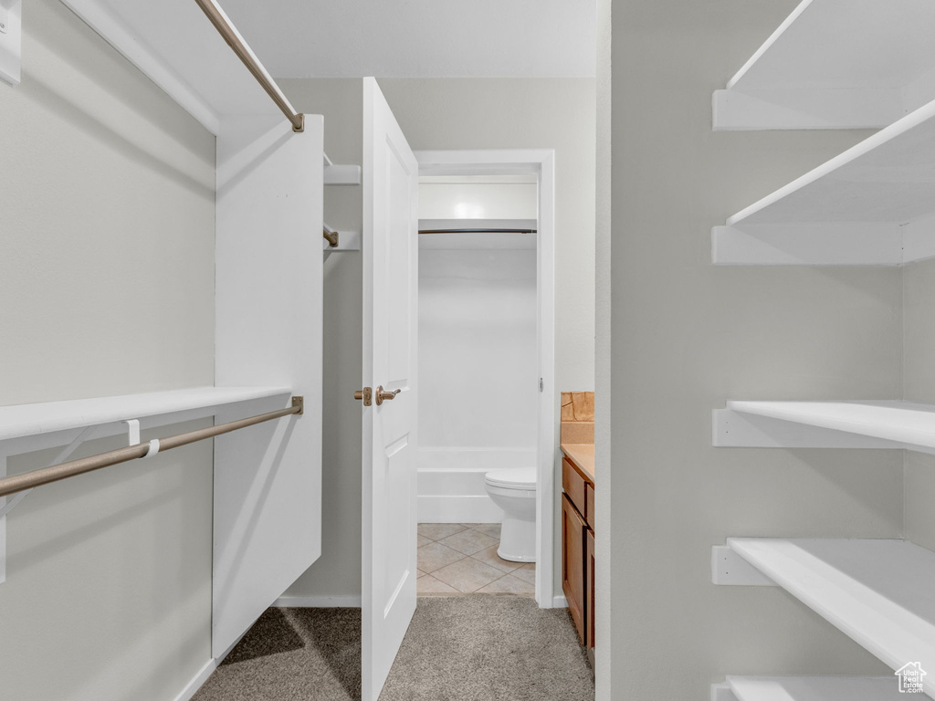 Spacious closet with light carpet and light tile patterned flooring