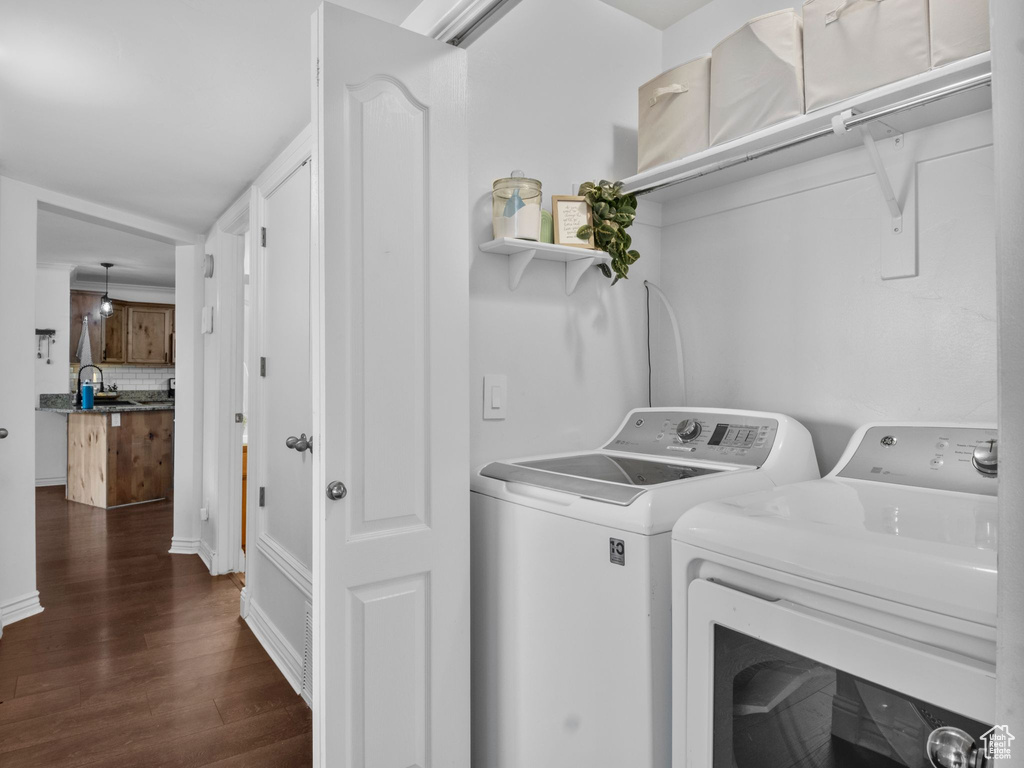 Laundry area with washer and dryer and dark wood-style flooring