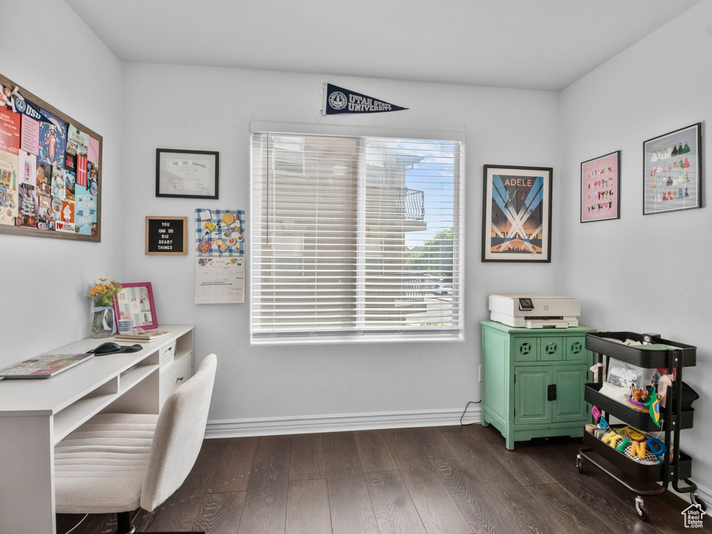 Office area with dark wood-style floors and baseboards