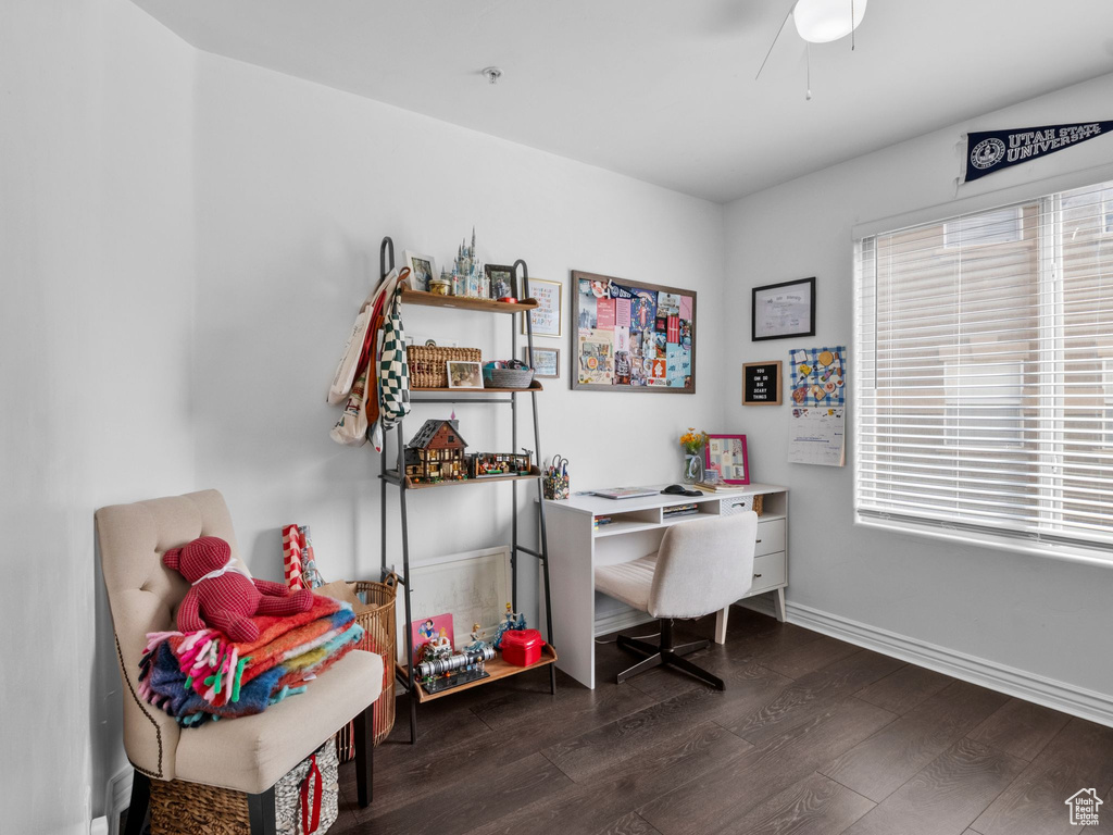 Home office with a ceiling fan, dark wood-style flooring, and baseboards