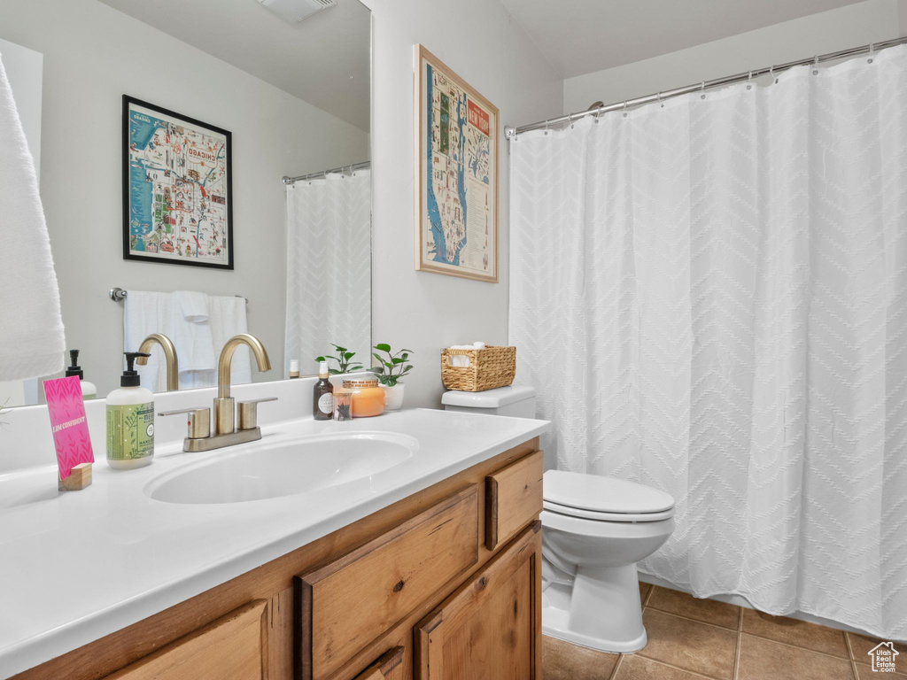 Full bathroom with vanity, tile patterned floors, and toilet