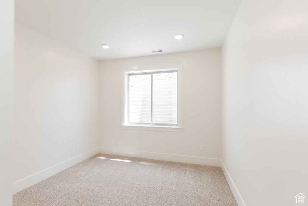 Empty room with baseboards, light carpet, and recessed lighting