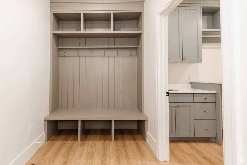 Mudroom with light wood finished floors and baseboards