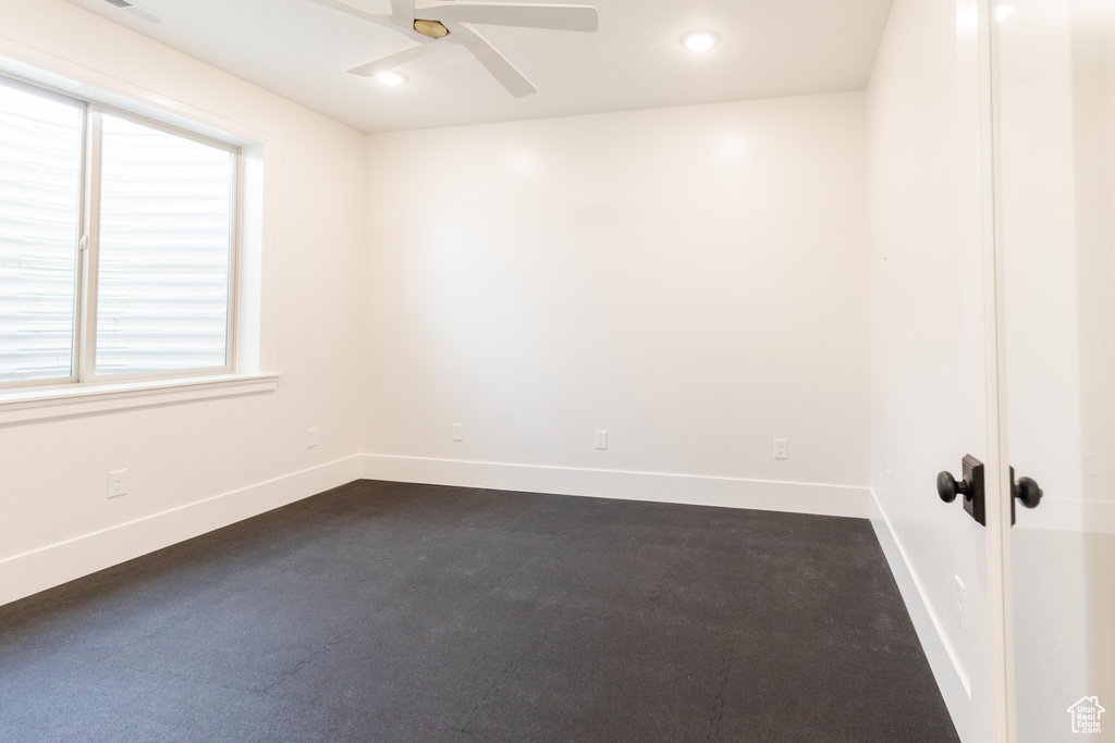 Spare room with a ceiling fan, baseboards, dark carpet, and recessed lighting