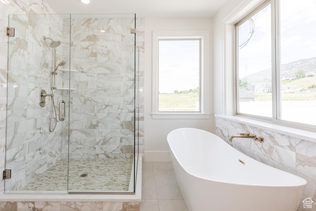 Bathroom with a stall shower, a soaking tub, and tile patterned floors