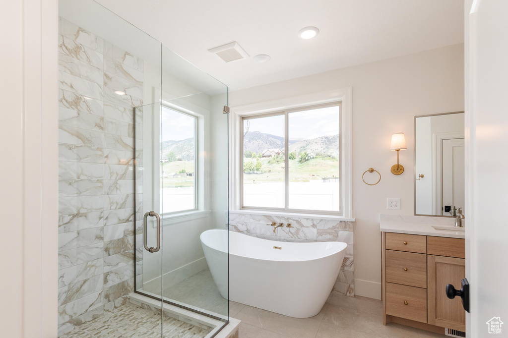 Bathroom with a freestanding bath, vanity, a shower stall, tile patterned flooring, and a mountain view