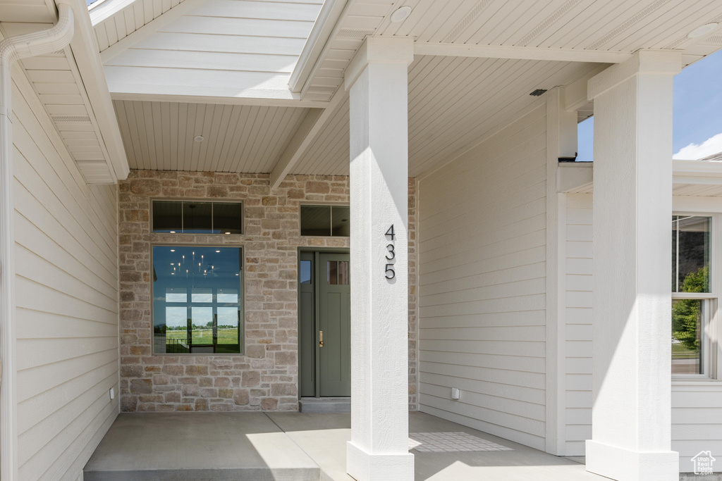 Property entrance featuring stone siding and a porch