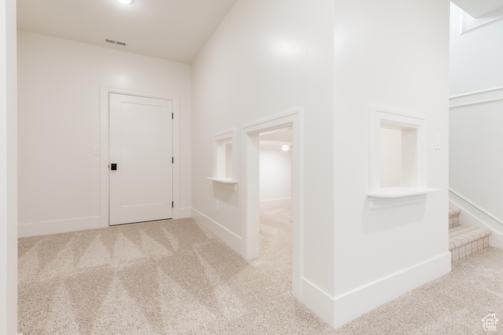 Hallway with carpet and baseboards
