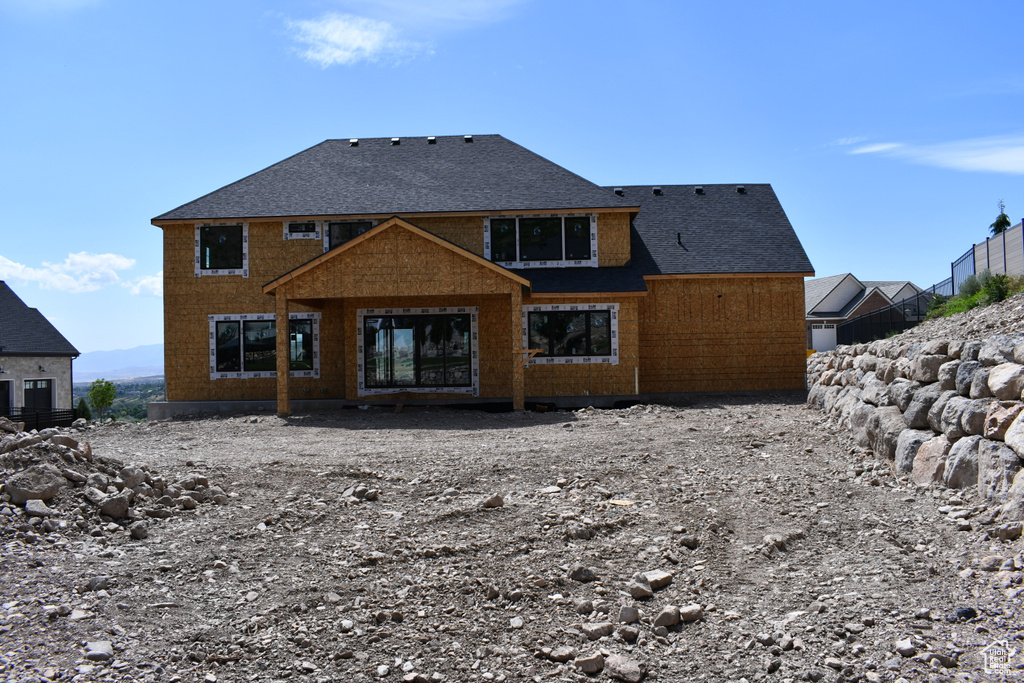 Back of property with a shingled roof