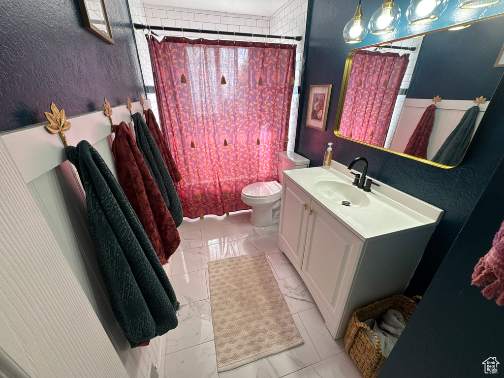Full bath with marble finish floors, vanity, and toilet