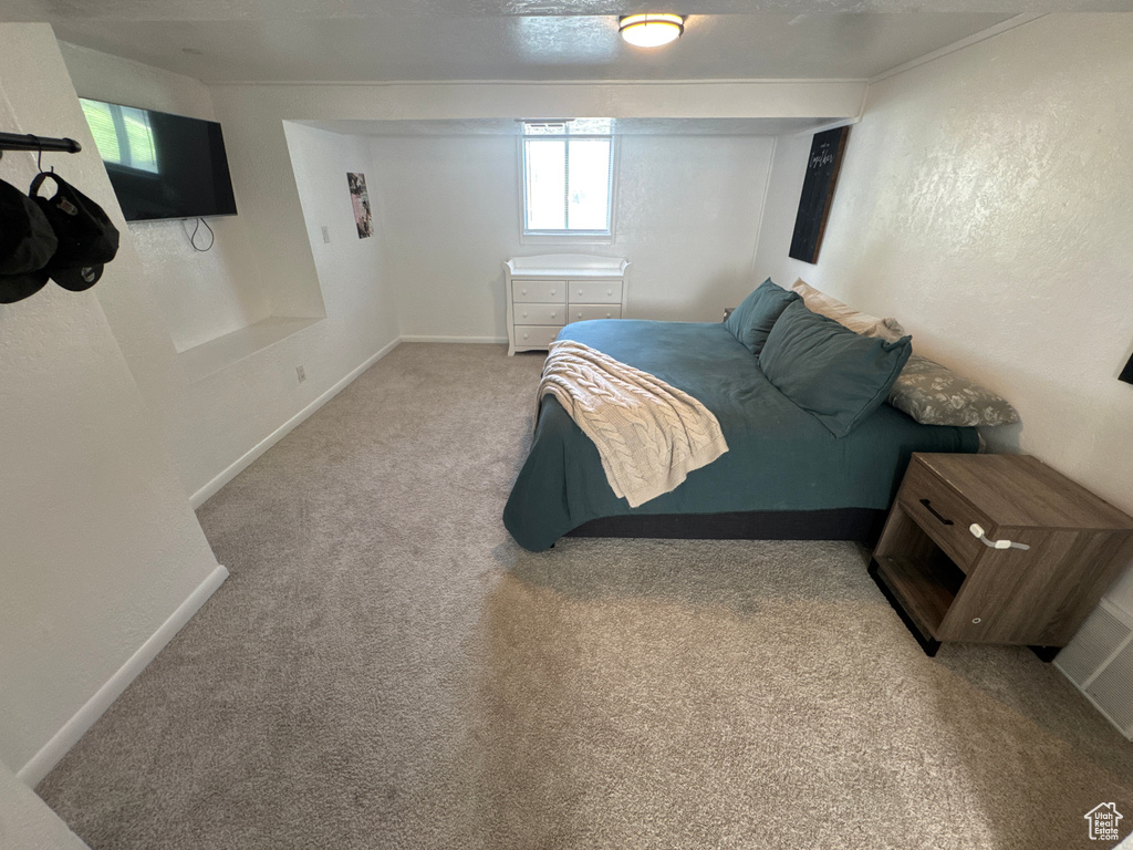 Bedroom featuring light carpet and baseboards