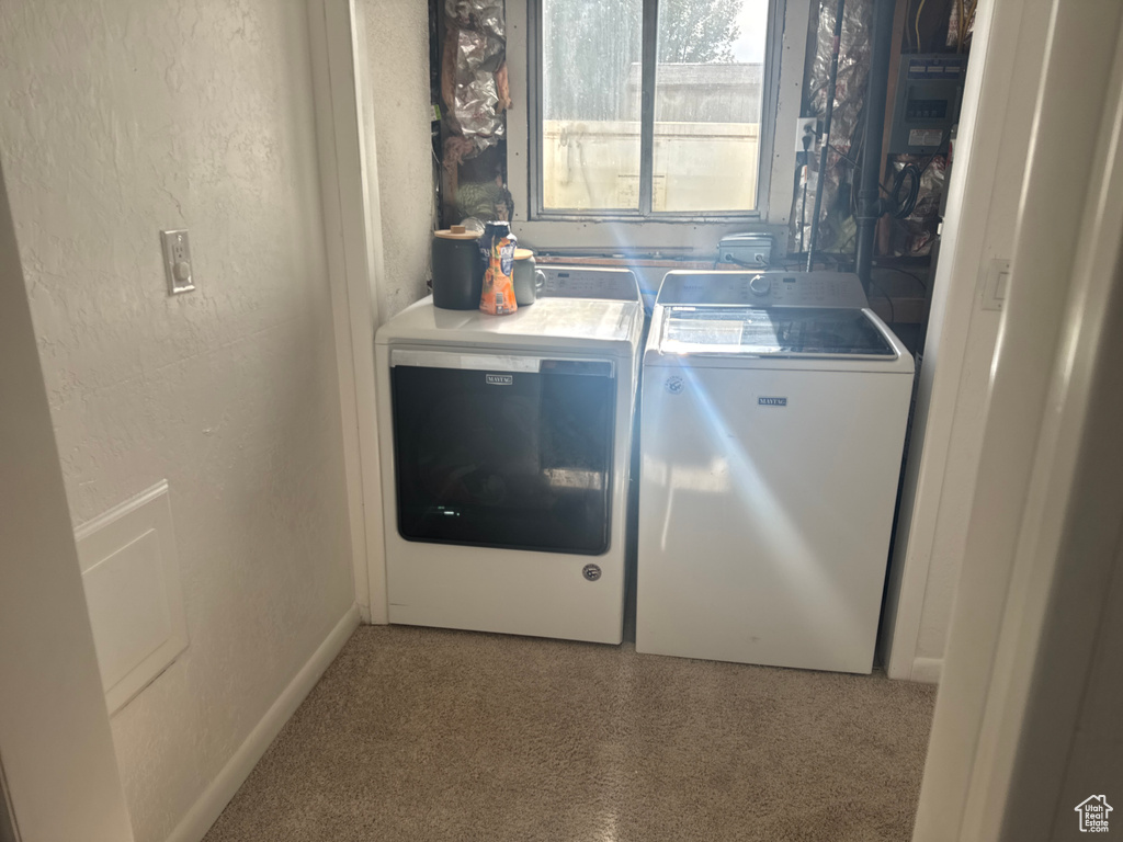 Laundry room with independent washer and dryer and a textured wall