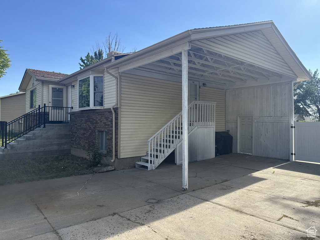View of parking / parking lot featuring concrete driveway and an attached carport
