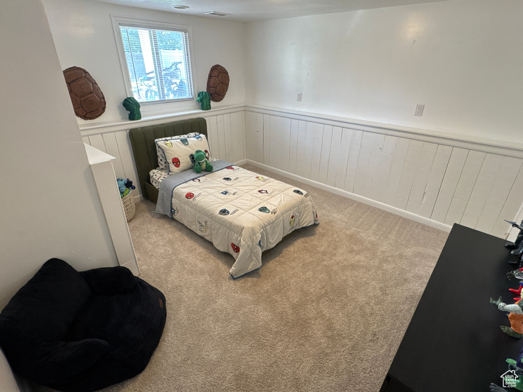 Bedroom featuring wainscoting and carpet
