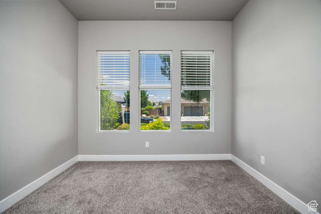 Empty room with plenty of natural light, carpet floors, and baseboards