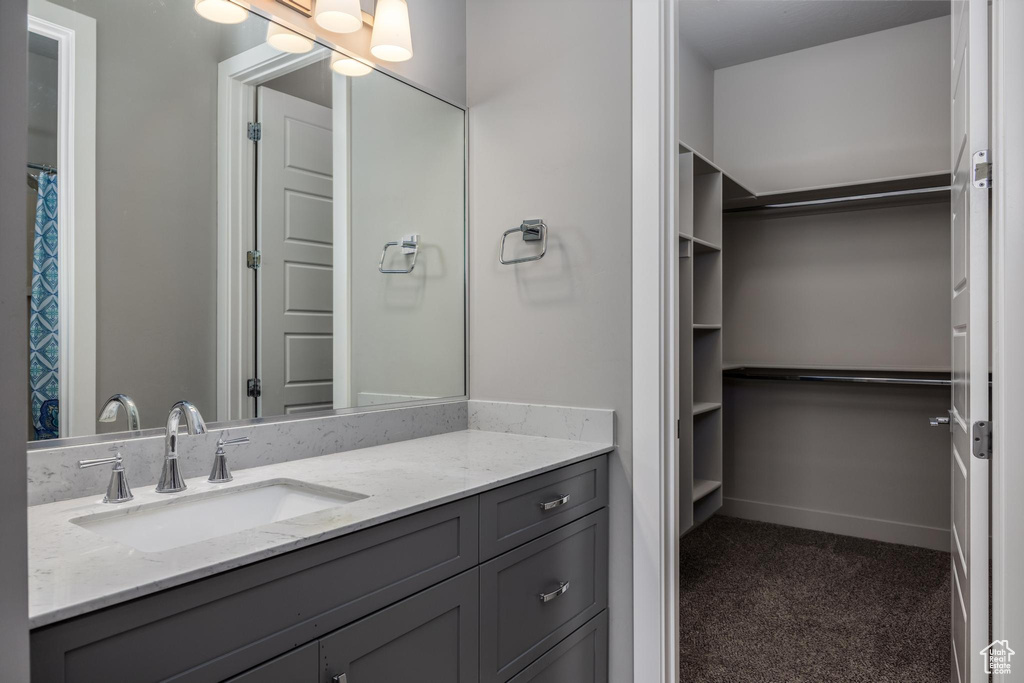 Full bath with vanity and a walk in closet