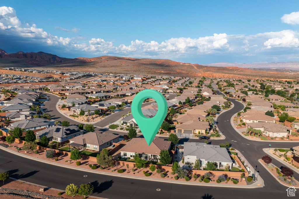 Aerial view of property and surrounding area with a mountain backdrop and nearby suburban area