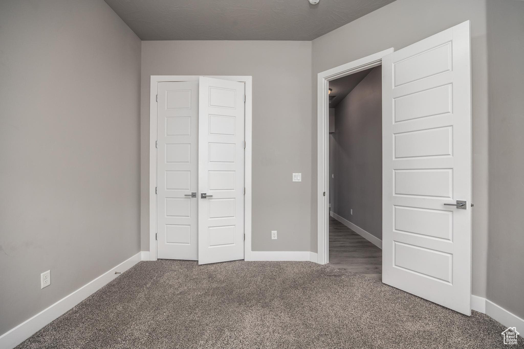 Unfurnished bedroom with carpet flooring, baseboards, and a closet