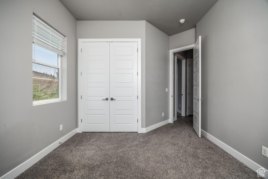 Unfurnished bedroom featuring carpet flooring, a closet, and baseboards