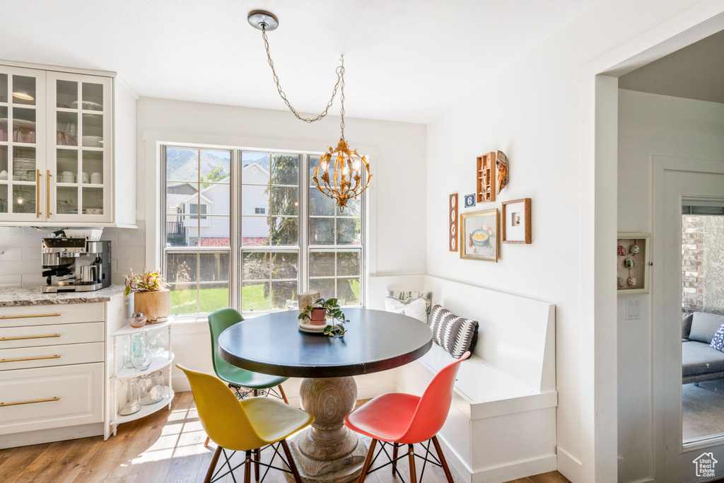 Dining area featuring light wood-type flooring and a chandelier