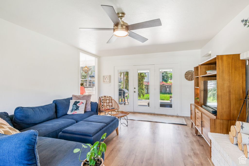 Living area with light wood-style flooring, ceiling fan, and french doors