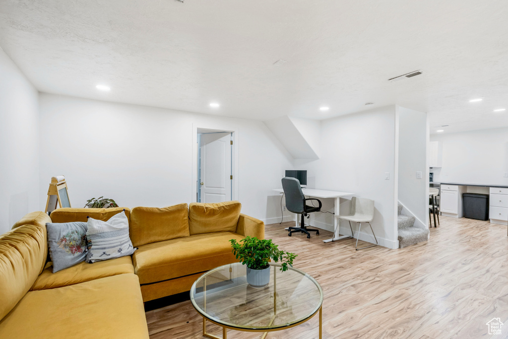 Living area featuring a desk, wood finished floors, recessed lighting, stairs, and baseboards