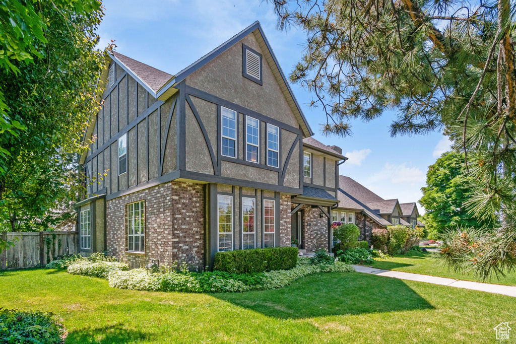 Back of property with brick siding, board and batten siding, stucco siding, and a shingled roof