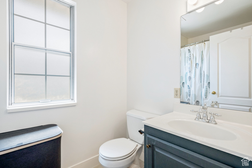 Full bath with vanity, toilet, and baseboards